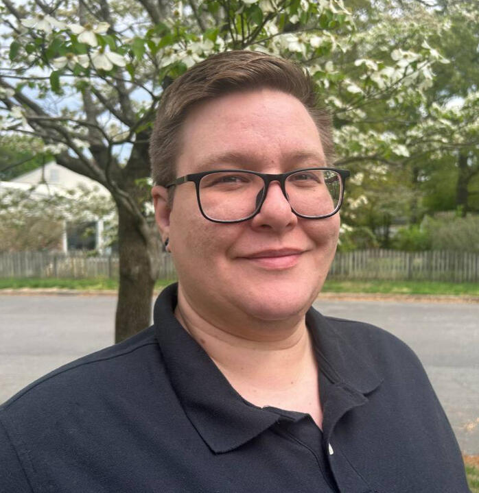 Photo of Quinn, a non-binary person with light hair and glasses.